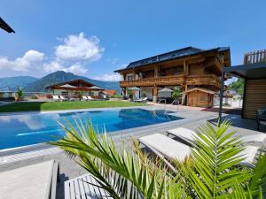 a villa with a swimming pool and a house at Pension Edelweiß in Sankt Johann im Pongau