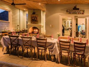 comedor con mesa, sillas y chimenea en Hedge House Guest House, en Ciudad del Cabo