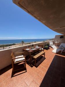 a patio with a table and chairs and the beach at Fully equipped seaview Cabezo flat in El Médano