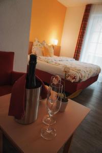 a room with a bed and a table with a bottle of wine at Steakhüsli Hotel- Restaurant in Schopfheim