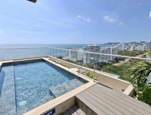 a swimming pool on top of a building with the ocean at Exclusivo apartasuite con terraza y vista al mar - Bello Horizonte in Santa Marta +31 photos