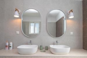 two sinks in a bathroom with two mirrors at Thea Luxury Villa in Kos +41 photos