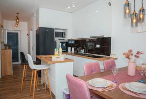a kitchen and dining room with a table and pink chairs at Apartment Matko in Ploče