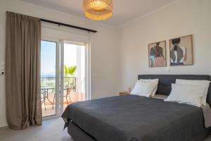 a bedroom with a bed with a view of the ocean at Thea Luxury Villa in Kos