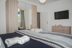 a bedroom with a large bed with towels on it at Apartment Matko in Ploče