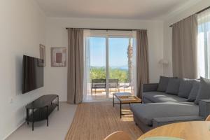a living room with a couch and a table at Thea Luxury Villa in Kos