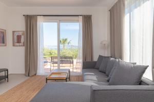 a living room with a couch and a large window at Thea Luxury Villa in Kos