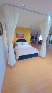 a bedroom with a bed with curtains and a wooden floor at Your Private Escape with city views in Auckland