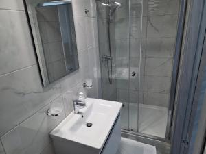 a white bathroom with a sink and a shower at Coastline, Lovely Seafront Apartment in Birżebbuġa +29 photos