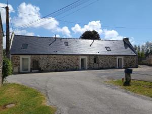 a stone building with a roof on a street at Charmant T2 - 4 couchages à 15mn de la mer in Merlevenez