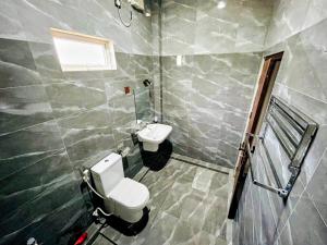 a bathroom with a toilet and a sink at Vish Homes in Nallur