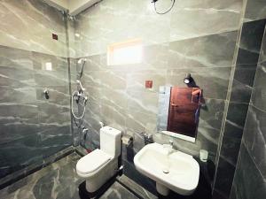 a bathroom with a sink and a toilet and a mirror at Vish Homes in Nallur