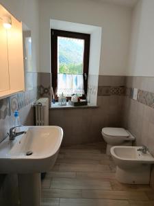 a bathroom with two sinks and a toilet and a window at Chez Bonjour in Villar Pellice +36 photos