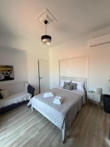 a bedroom with a large bed and a couch at METHONI LUXURY House in Methoni