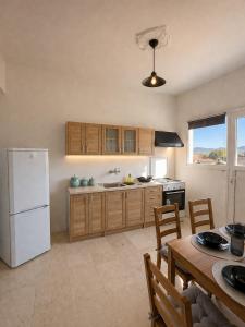 a kitchen with a white refrigerator and a table at METHONI LUXURY House in Methoni