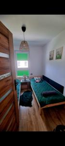a bedroom with a green bed and a window at Leśna Przystań Rumia - obok Gdyni i Aquaparku Reda in Rumia +102 photos