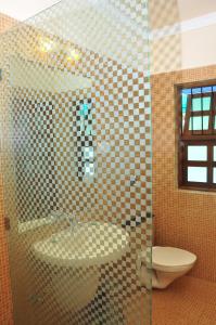 a bathroom with a shower with a sink and a toilet at Villa Theresa Beach Resort in Calangute