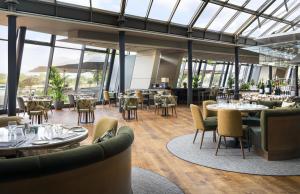 a restaurant with tables and chairs and windows at Hyatt Regency Mainz in Mainz