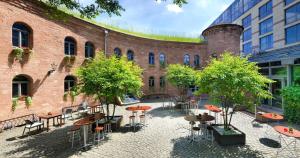 a courtyard with tables and chairs in front of a brick building at Hyatt Regency Mainz in Mainz