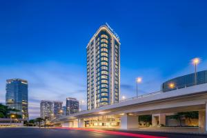 a tall building in a city at night at Ji Hotel Phnom Penh Downtown in Phnom Penh