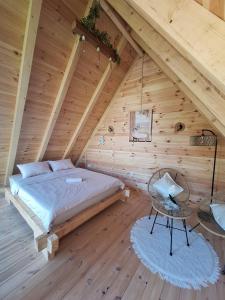 a bedroom with a bed in a wooden attic at SkyFrame cottage with pool in Plav