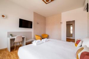 a bedroom with a large white bed and a desk at Urbanicooh Cavour Rooms&Suite in Bologna