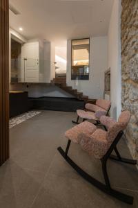 a living room with two chairs and a kitchen at Rial Collection Luxury Suite in Syracuse