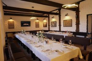 a long table in a restaurant with white tables and chairs at DREAM HOTEL Sambir in Sambir