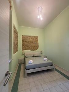 a bedroom with a bed and a brick wall at La Gradinata in Gonnosfanàdiga