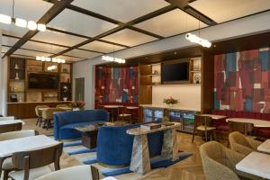 a lobby with tables and chairs and a television at Renaissance New York Midtown Hotel in New York