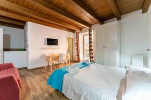 a bedroom with a white bed and a dining room at Cefalù Center Apartments in Cefalù