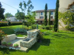 a garden with a stone fountain in the middle of a yard at Agriturismo La Rosta in Cervignano del Friuli