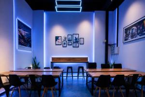 two tables and chairs in a room with blue walls at Hashtag.Capsule.Hostel in Johor Bahru