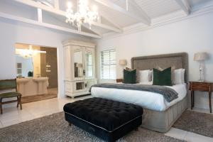 a bedroom with a large bed with a black ottoman at Brenaissance Wine & Stud Estate in Stellenbosch +109 photos