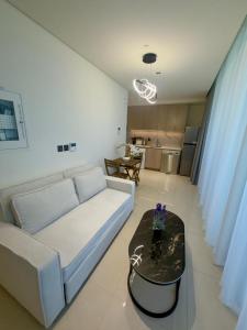 a living room with a white couch and a table at Beautiful Studio Retreat in Ras al Khaimah