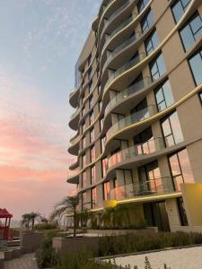 a rendering of a tall building with a sunset in the background at Beautiful Studio Retreat in Ras al Khaimah