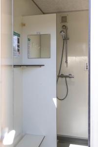 a shower in a bathroom with a glass door at Safaritent bij speeltuin voor gezinnen op groen rustig park op de Veluwe in Epe