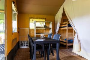 a dining room with a table and chairs and a tent at Safaritent bij speeltuin voor gezinnen op groen rustig park op de Veluwe in Epe