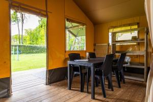 a dining room with a table and chairs at Safaritent bij speeltuin voor gezinnen op groen rustig park op de Veluwe in Epe +28 photos