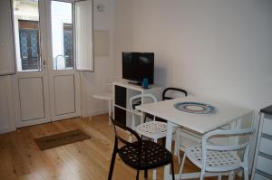 a small kitchen with a table and chairs and a television at Casa do Chafariz in Cascais