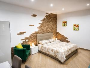 a bedroom with a bed and a brick wall at Domus Cuomo B&B in Nocera Inferiore