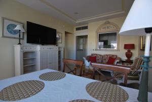 a living room with a table and a television at Apartamentos Guadalpin Boutique in Marbella