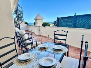 a table with glasses and plates on a balcony at Apartamentos Guadalpin Boutique in Marbella