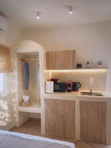 a kitchen with wooden cabinets and a sink at Mora Houses in Mandrakia +12 photos