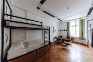 a bedroom with two bunk beds and a table at Party Hostel Zzz in Ljubljana +97 photos