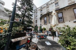 an outdoor patio with tables and chairs and an umbrella at Party Hostel Zzz in Ljubljana