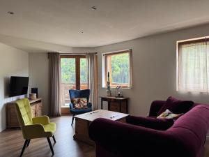 a living room with a purple couch and two chairs at Le balcon du Chemin des Vignes ! in Bozel