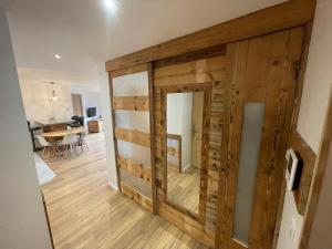 a room with a wooden wall with a mirror at Le balcon du Chemin des Vignes ! in Bozel