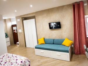 a living room with a blue couch with yellow pillows at Domus Cuomo B&B in Nocera Inferiore