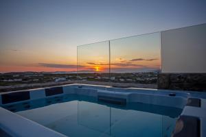 a view of a sunset from a building with a hot tub at Mystic Horizon in Mikonos